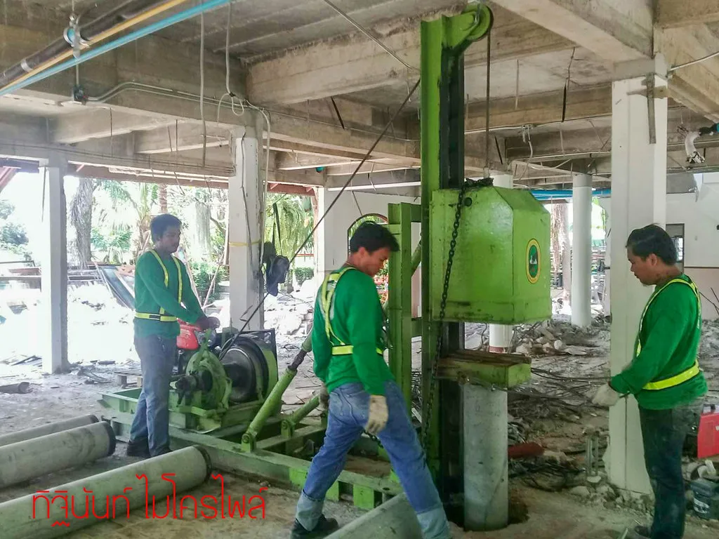 ทีมงานตอกไมโครไพล์ด้วยปั้นจั่นขนาดกะทัดรัดใต้พื้นคอนกรีตชั้นล่าง