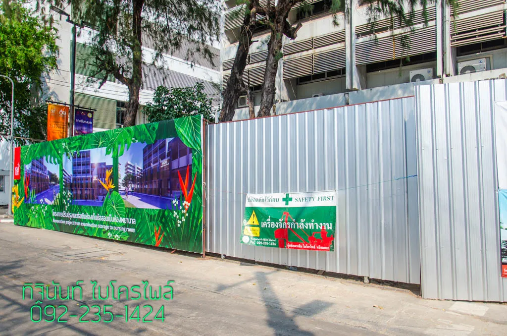 แนวรั้วโครงการพร้อมป้าย Safety First และป้ายเตือนเครื่องจักรกำลังทำงาน