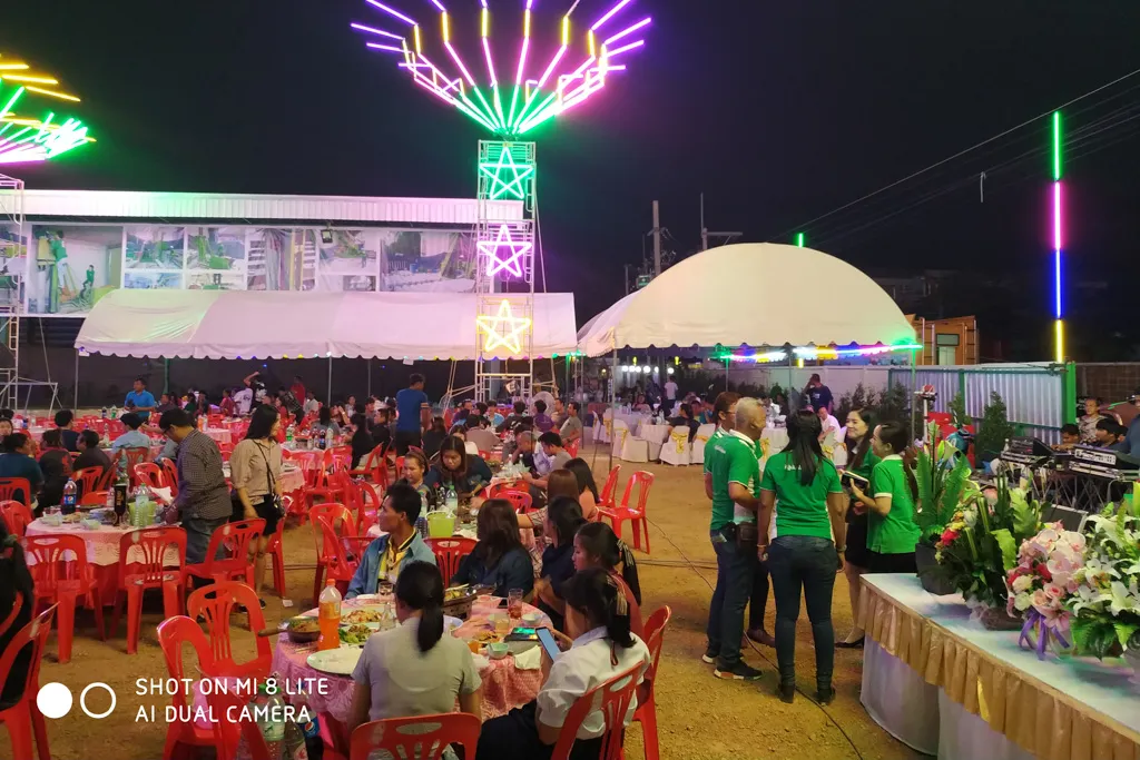 ผู้ร่วมงานนั่งรับประทานอาหารรอบโต๊ะในพื้นที่งานเลี้ยงช่วงค่ำ