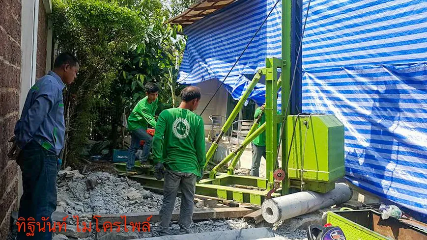 ทีมงานและปั้นจั่นไมโครไพล์ทำงานในช่องข้างบ้านที่มีพื้นที่จำกัด