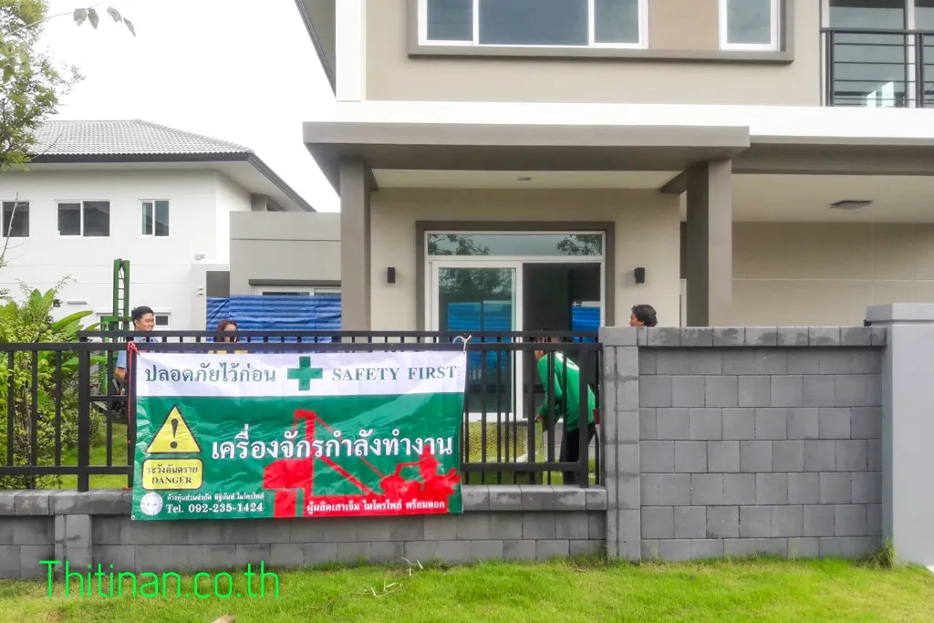ป้าย Safety First แจ้งเตือนเครื่องจักรกำลังทำงานติดอยู่ที่รั้วหน้าบ้าน