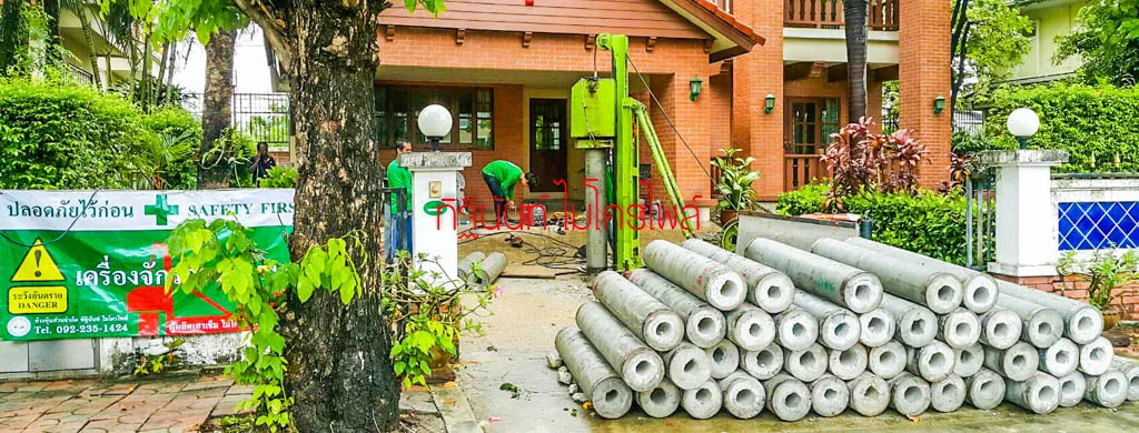 ภาพรวมปั้นจั่น กองท่อนเสาเข็ม และป้ายเตือนบริเวณหน้าบ้าน