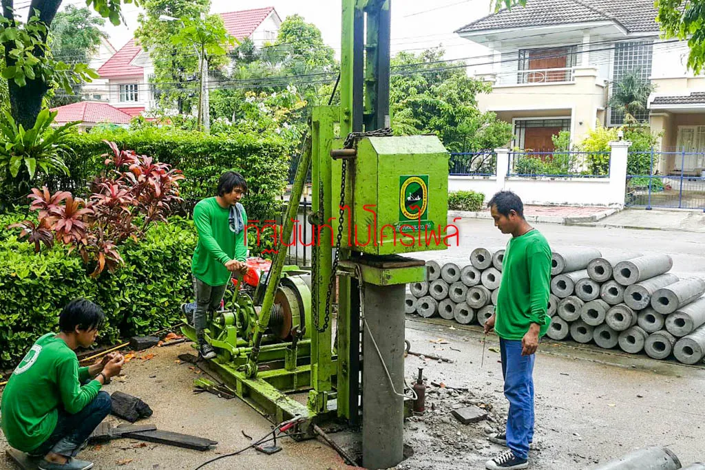 ทีมงานกับปั้นจั่นไมโครไพล์และกองท่อนเสาเข็มบริเวณหน้าบ้าน