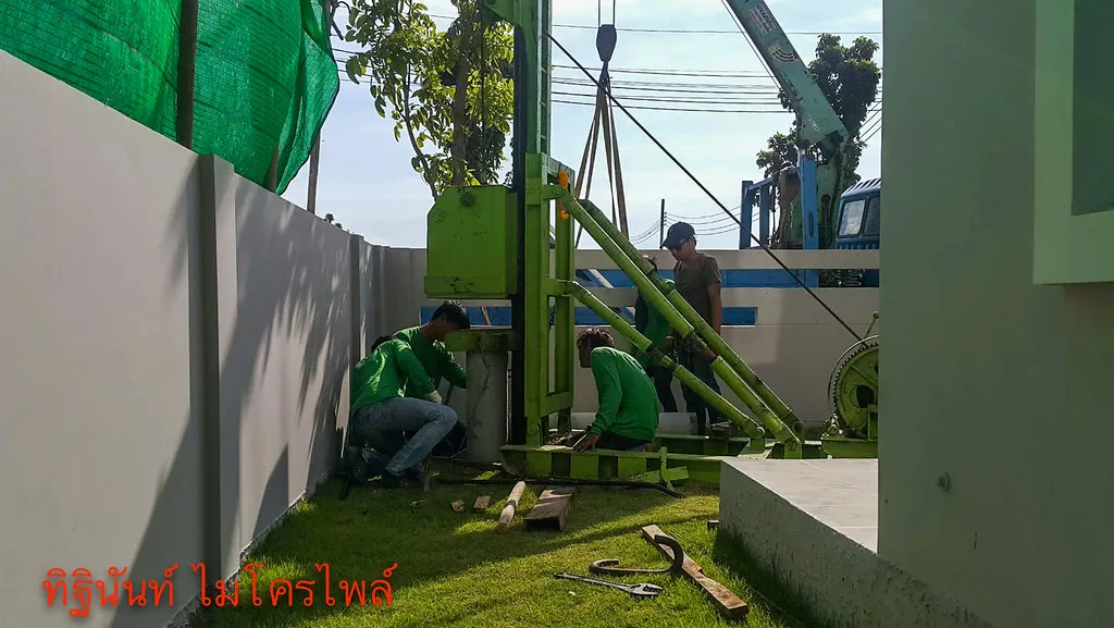ทีมงานทำงานที่ฐานปั้นจั่นพร้อมชุดสลิงจากรถเฮี๊ยบเหนือเครื่อง